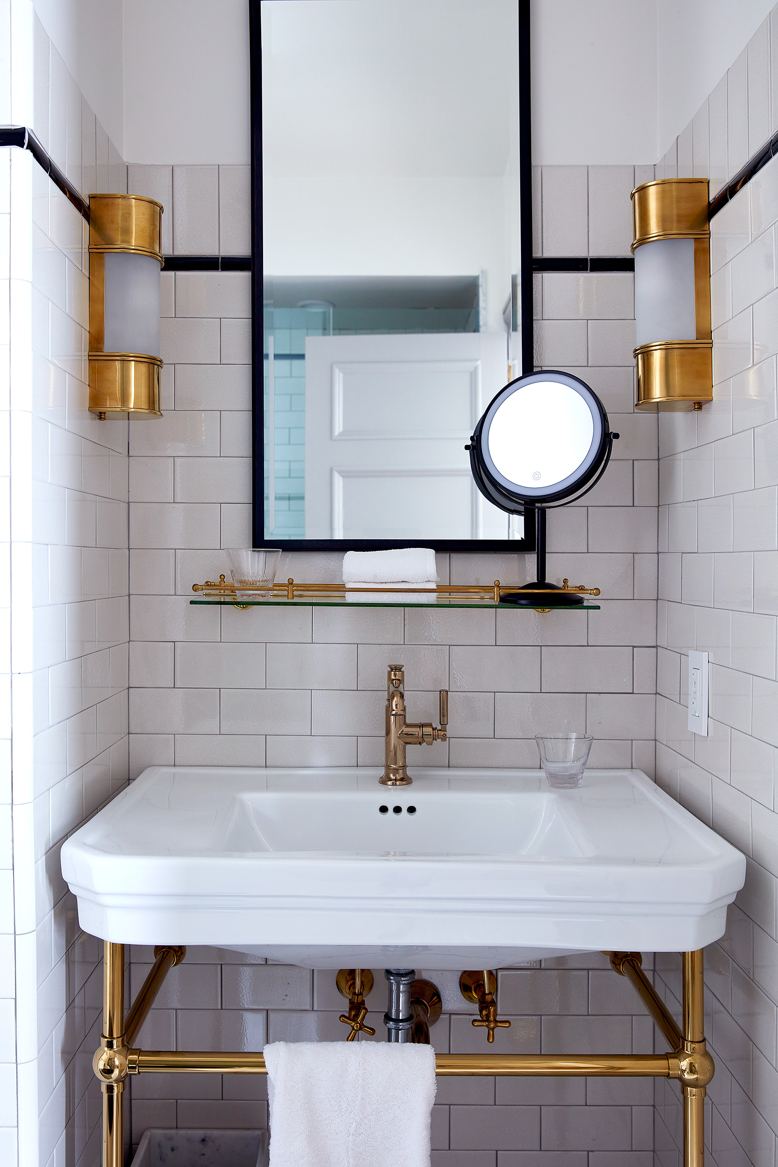 A classic black and white tiled bathroom with brass details.