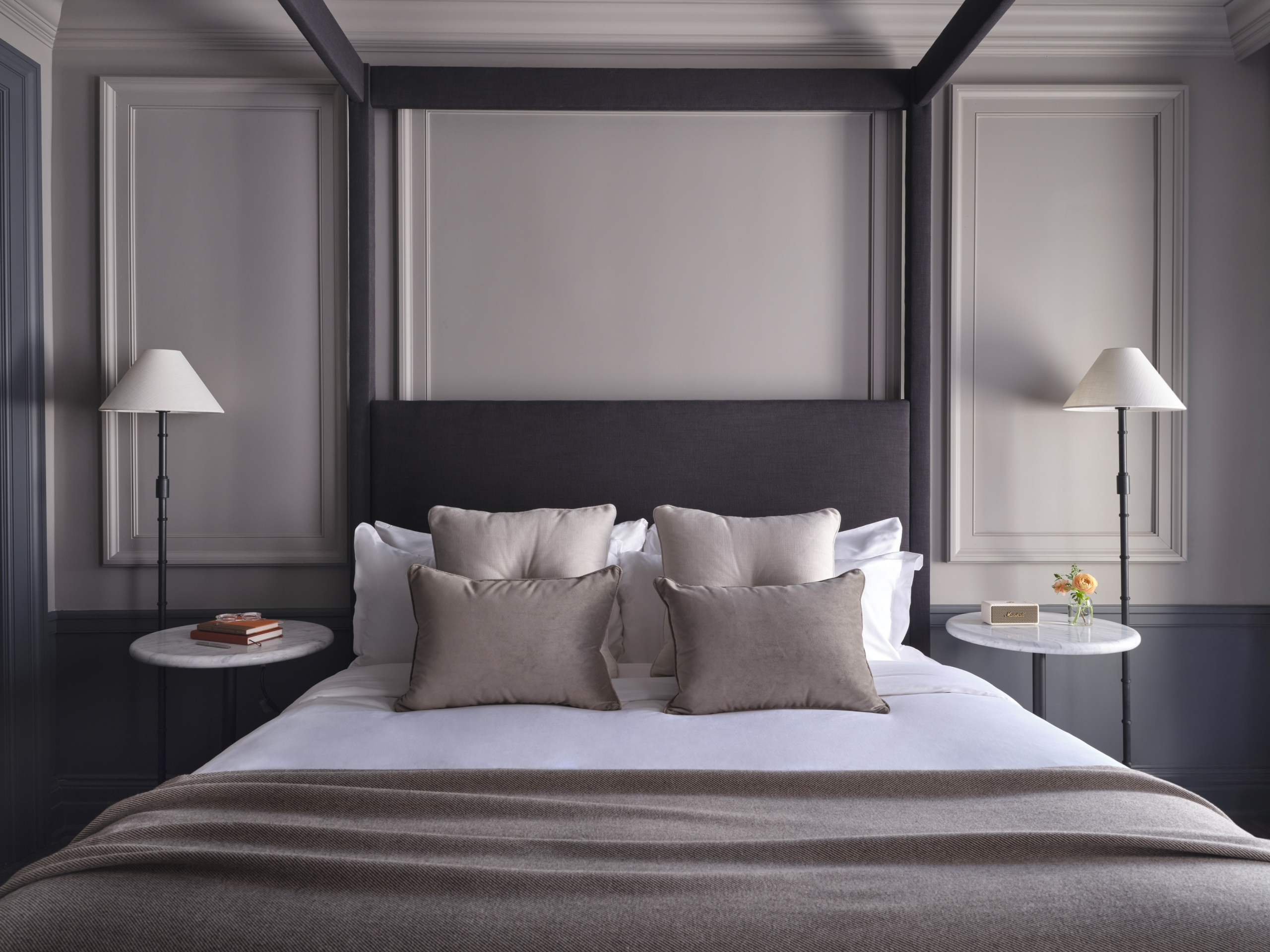 A view of a four poster king size bed with two marble top bedside tables